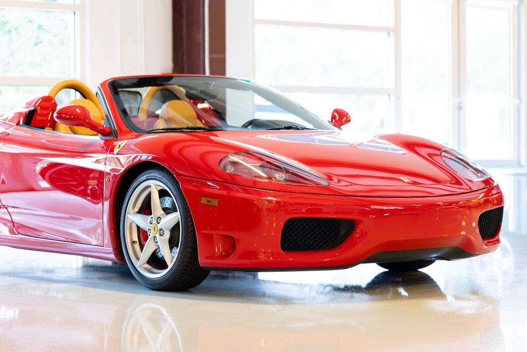 Red Ferrari 360 Spider with its soft top folded in the Rosner Motorsports showroom